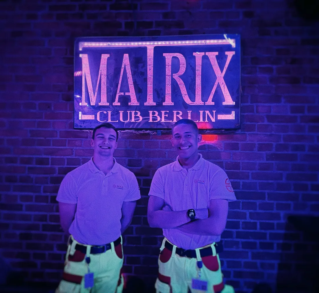 Zwei Sanitäter von SKALA Paramedics vor dem Leuchtschild des Matrix Club Berlin