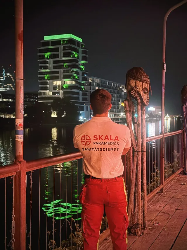SKALA Paramedics medic at a railing overlooking the illuminated city