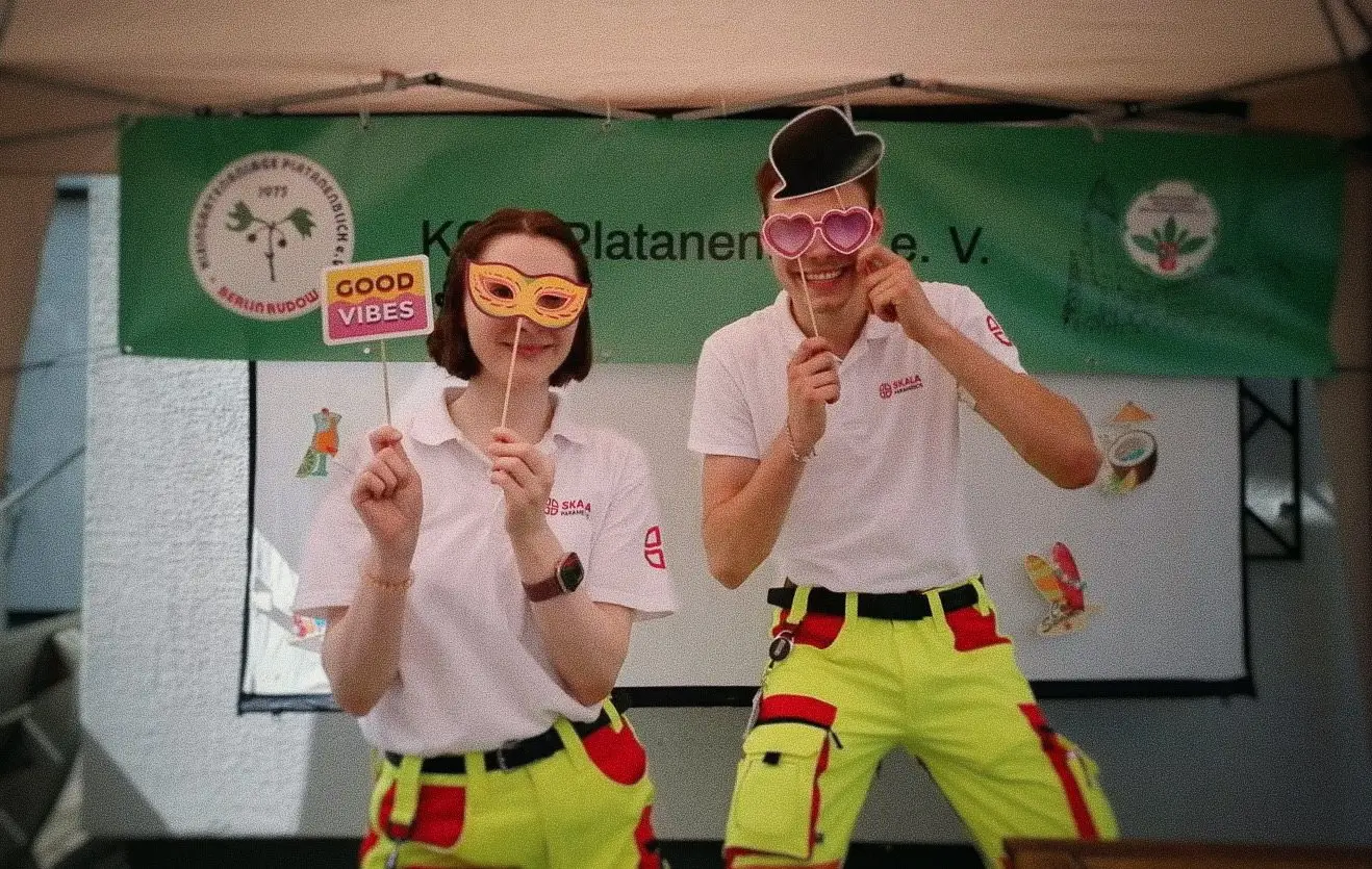 Sanitäterin und Sanitäter von SKALA Paramedics mit Fotobox-Accessoires auf einem Vereinsfest