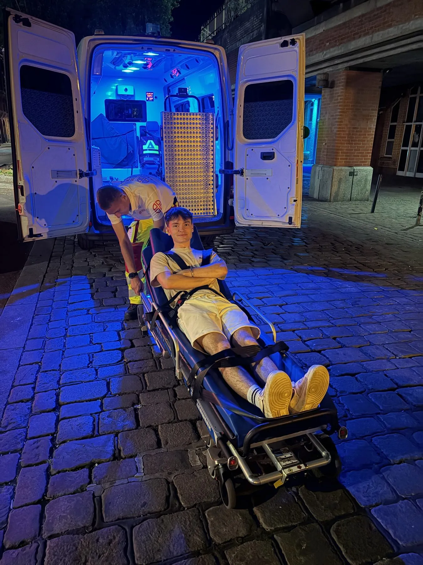 Sanitäter mit Trage am Krankentransportwagen bei Nacht