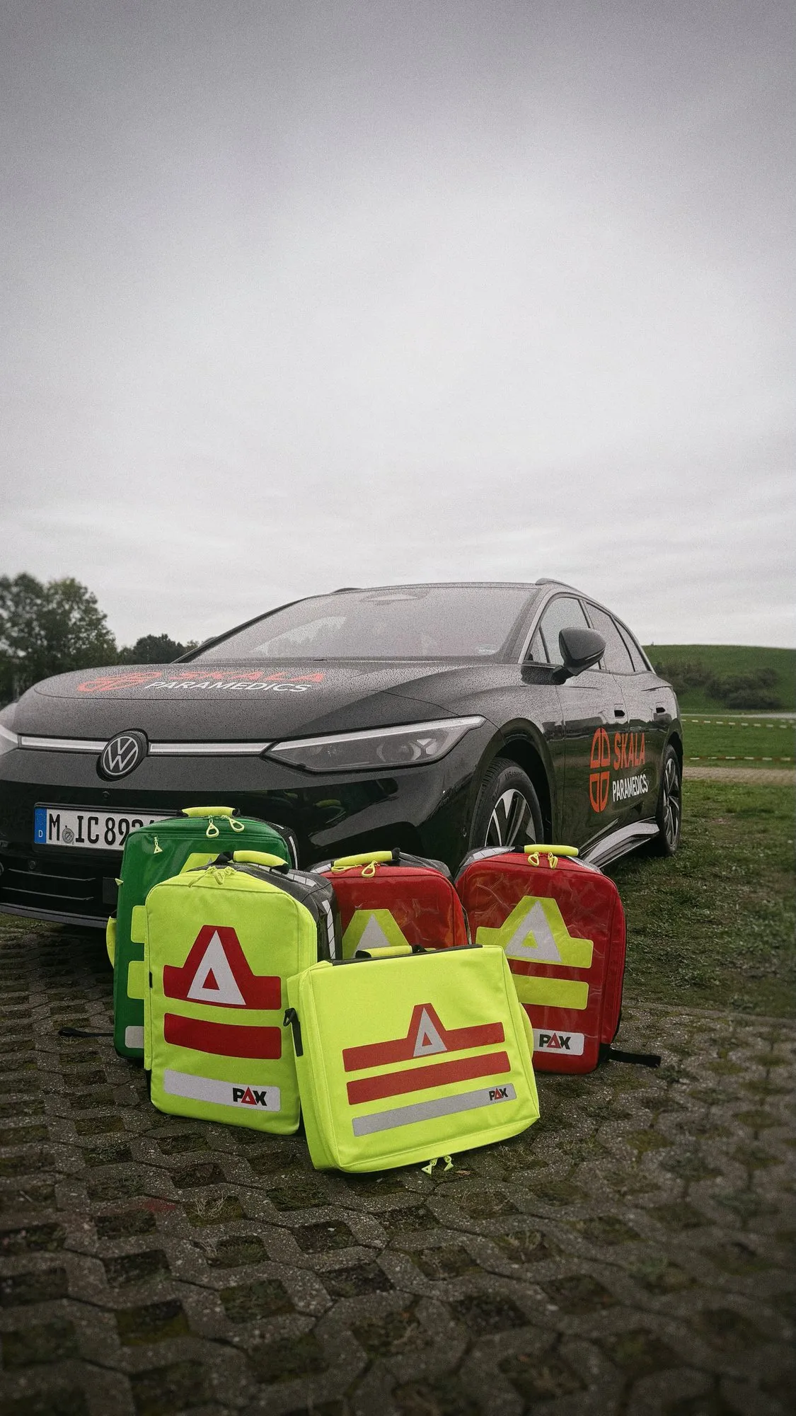 Mehrere Notfallrucksäcke vor dem schwarzen Field-Supervisor-Fahrzeug von SKALA