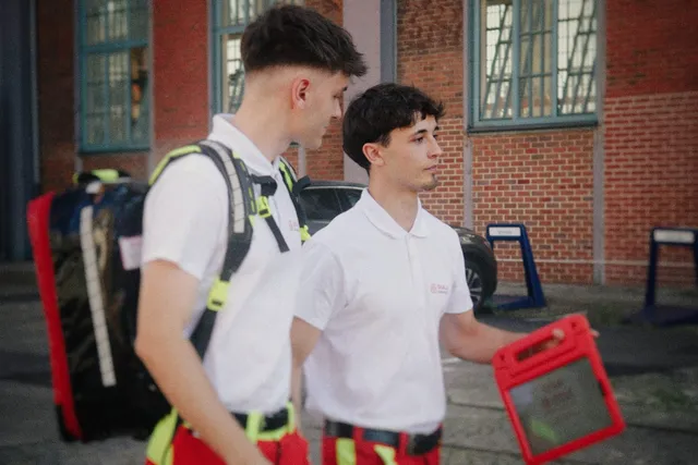 Two medics with backpack and tablet walking across the site