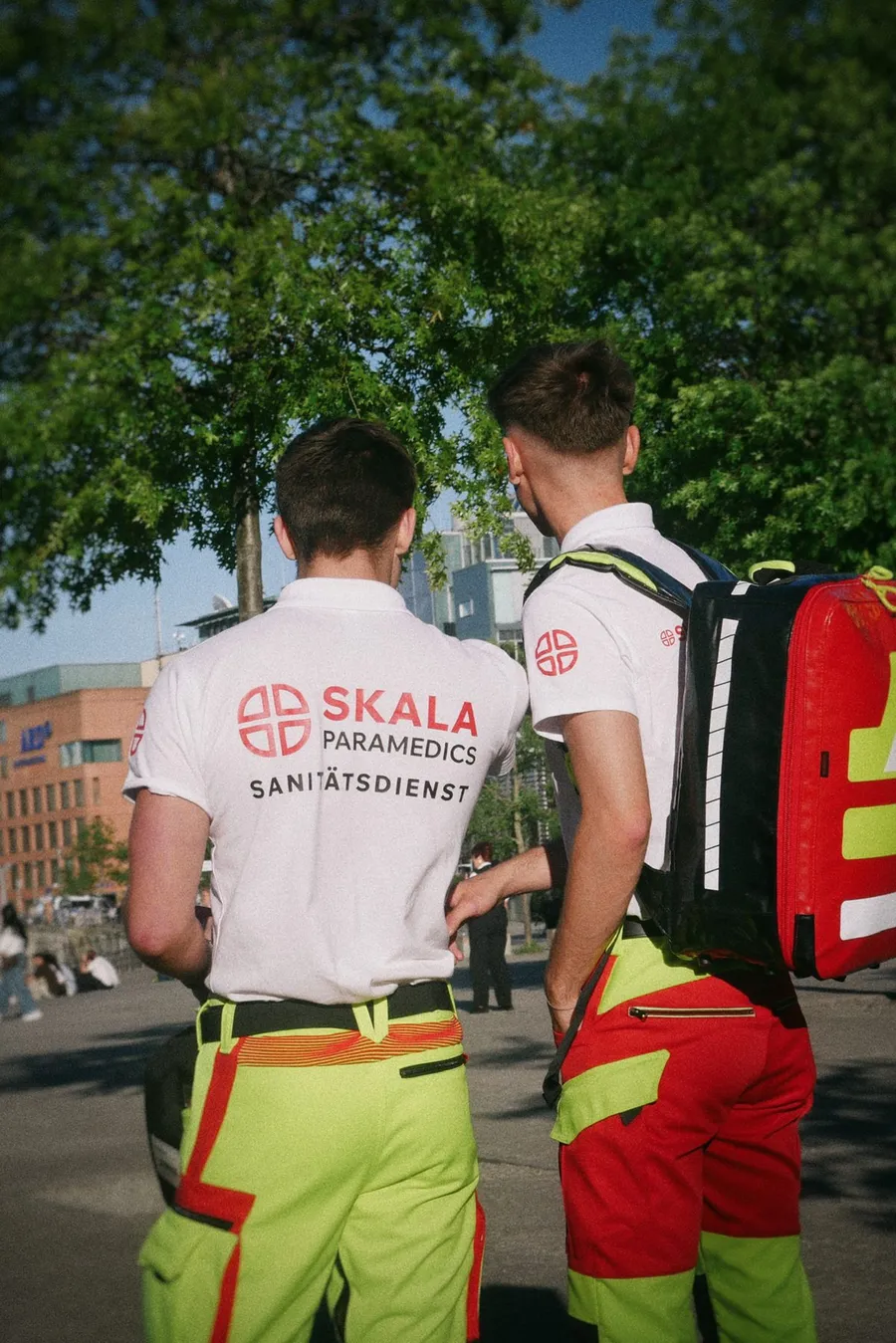 Two medics with SKALA back print and emergency backpack under trees
